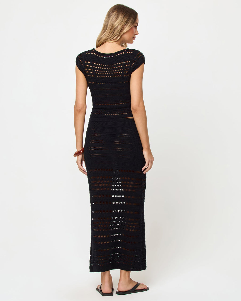 Haut court en maille crochet noire, col en V, manches courtes et boutonnage devant
